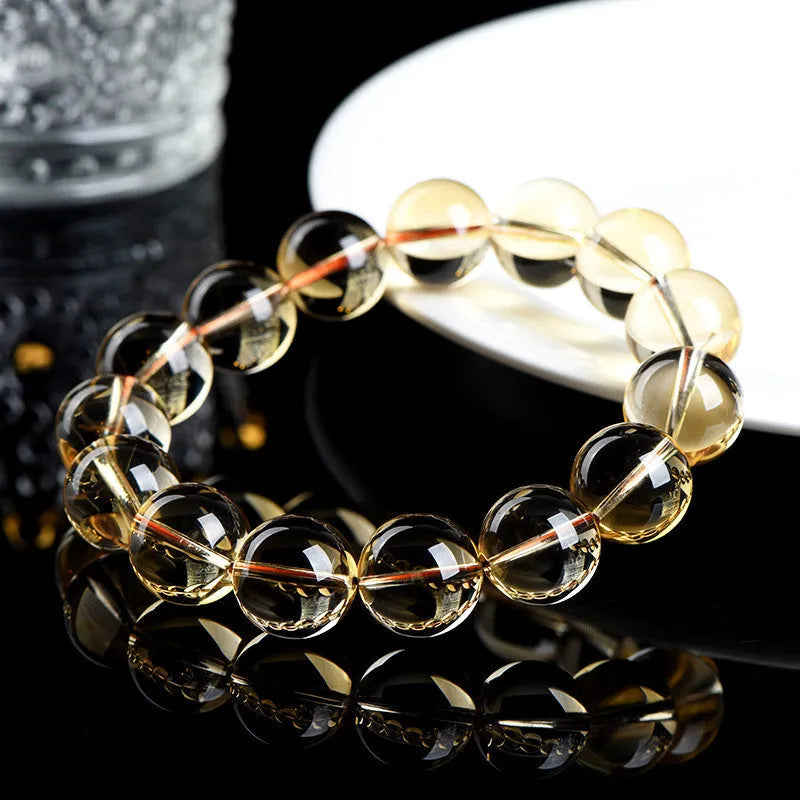 Original design bracelet with scattered, polished natural citrine beads in golden yellow tones on a wrist.