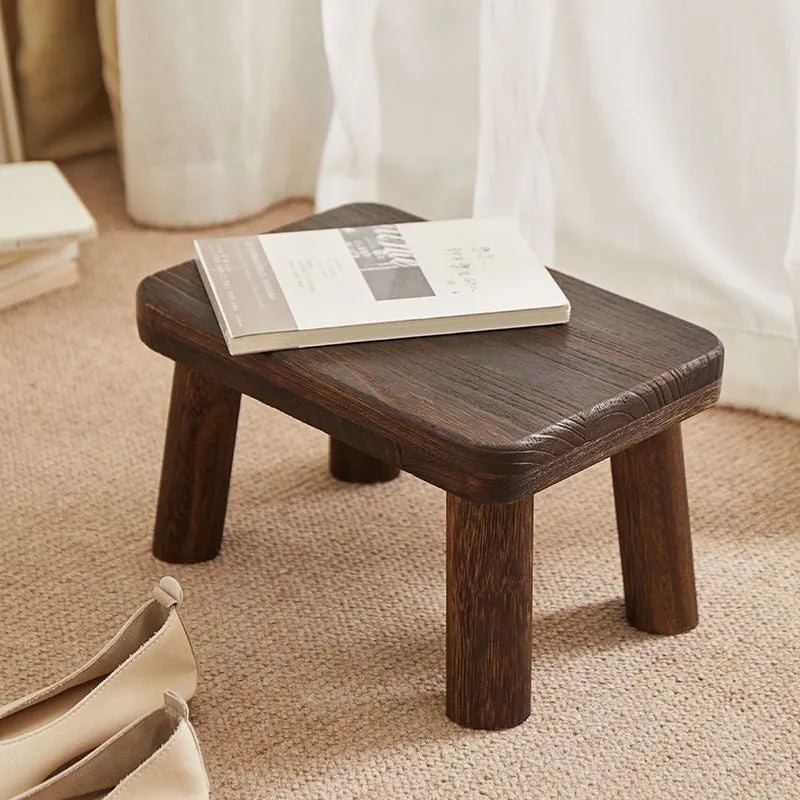 Solid wood distressed finish shoe changing stool with bracket legs.