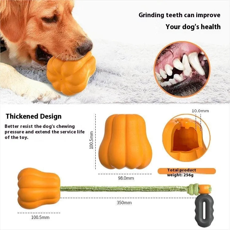 Orange plastic molar-shaped dog chew toy with rope, placed on grass for outdoor use.