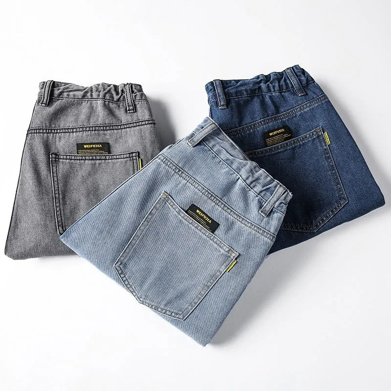Men's loose straight leg casual jeans in cotton, shown in dark blue, light blue, and grey colours.