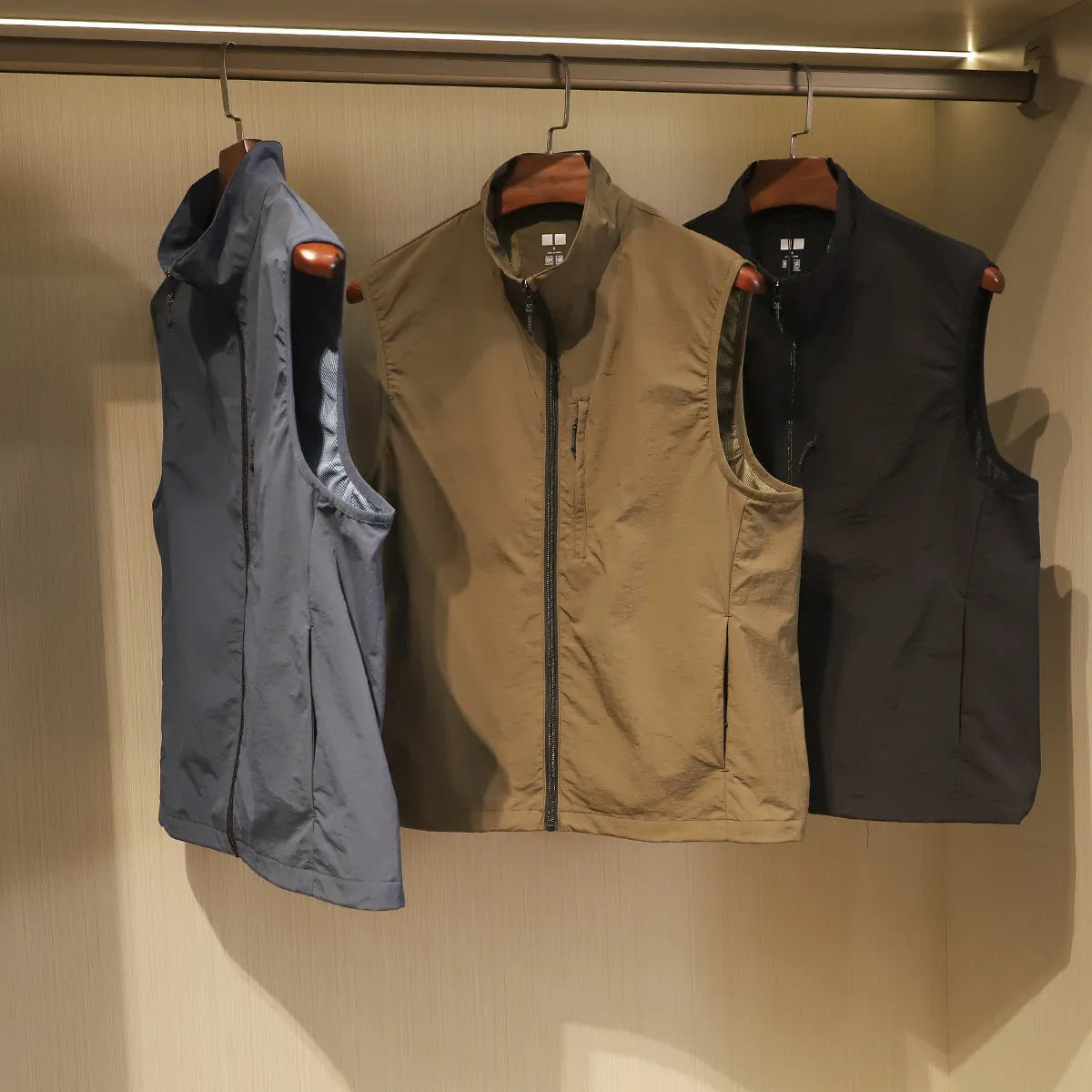 Men's thin nylon bandage-style vest in army green with side seam pockets on a hanger.