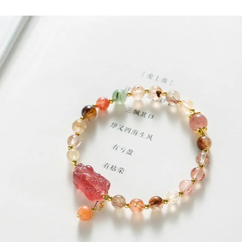 Natural strawberry quartz and copper bracelet with pearl accents on a wrist.