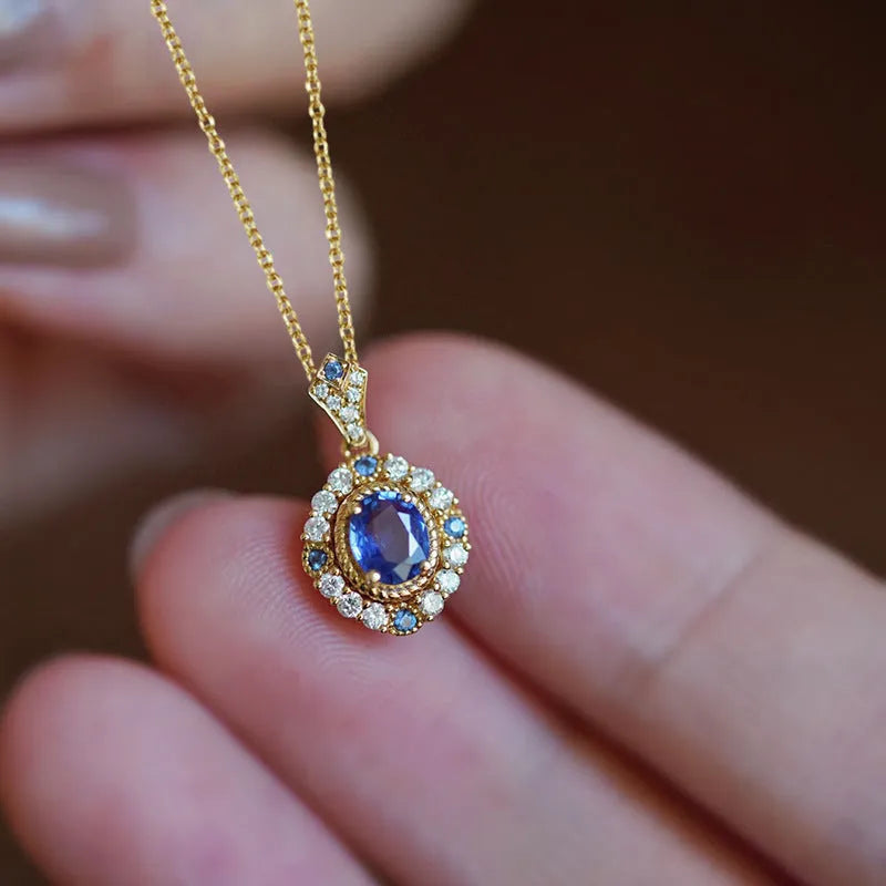 Yellow gold-colour adjustable box chain necklace with a mixed gemstone inlaid pendant on a white background.
