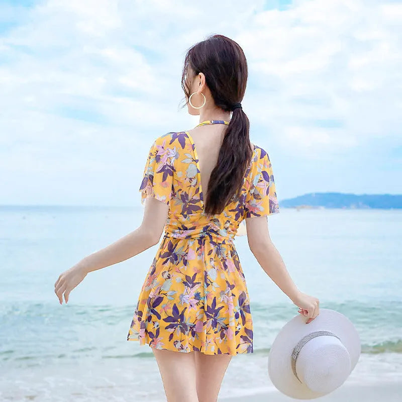 Yellow women's one-piece swimsuit with floral pattern on polyester fabric.