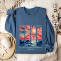 Blue loose-fit women's printed pullover sweater with drop-shoulder sleeves on a hanger.