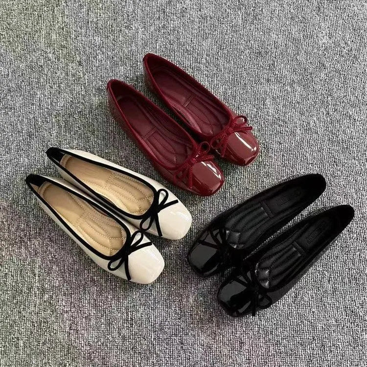 Pair of black patent leather Mary Jane flats with low heel and round toe