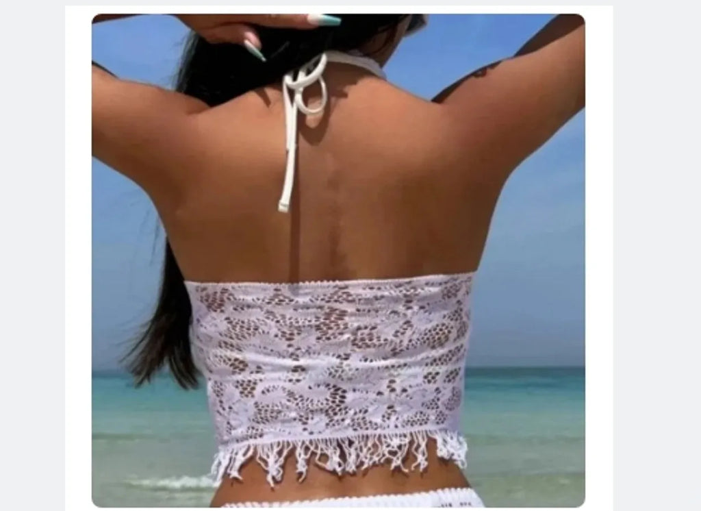 Women's white lace-up bikini set with matching tassel skirt for beach wear