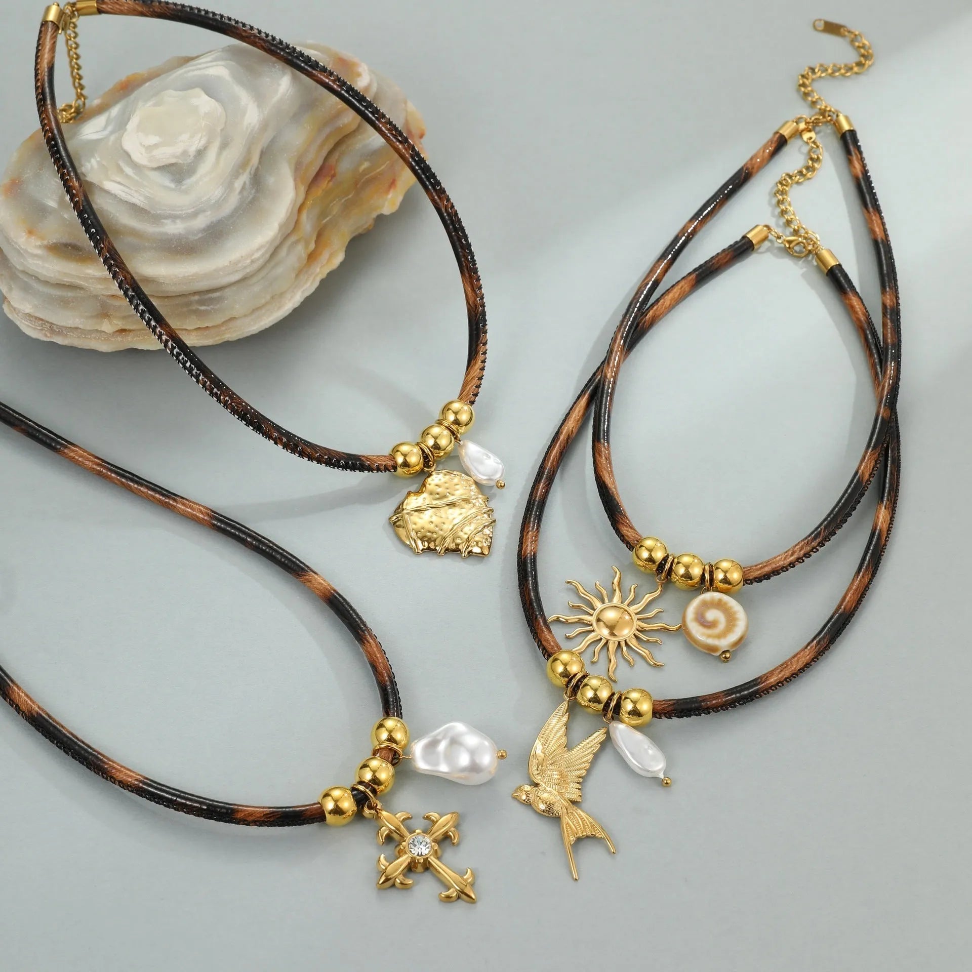 Geometric stainless steel necklace with leopard leather accents on pendant and gold-plated chain