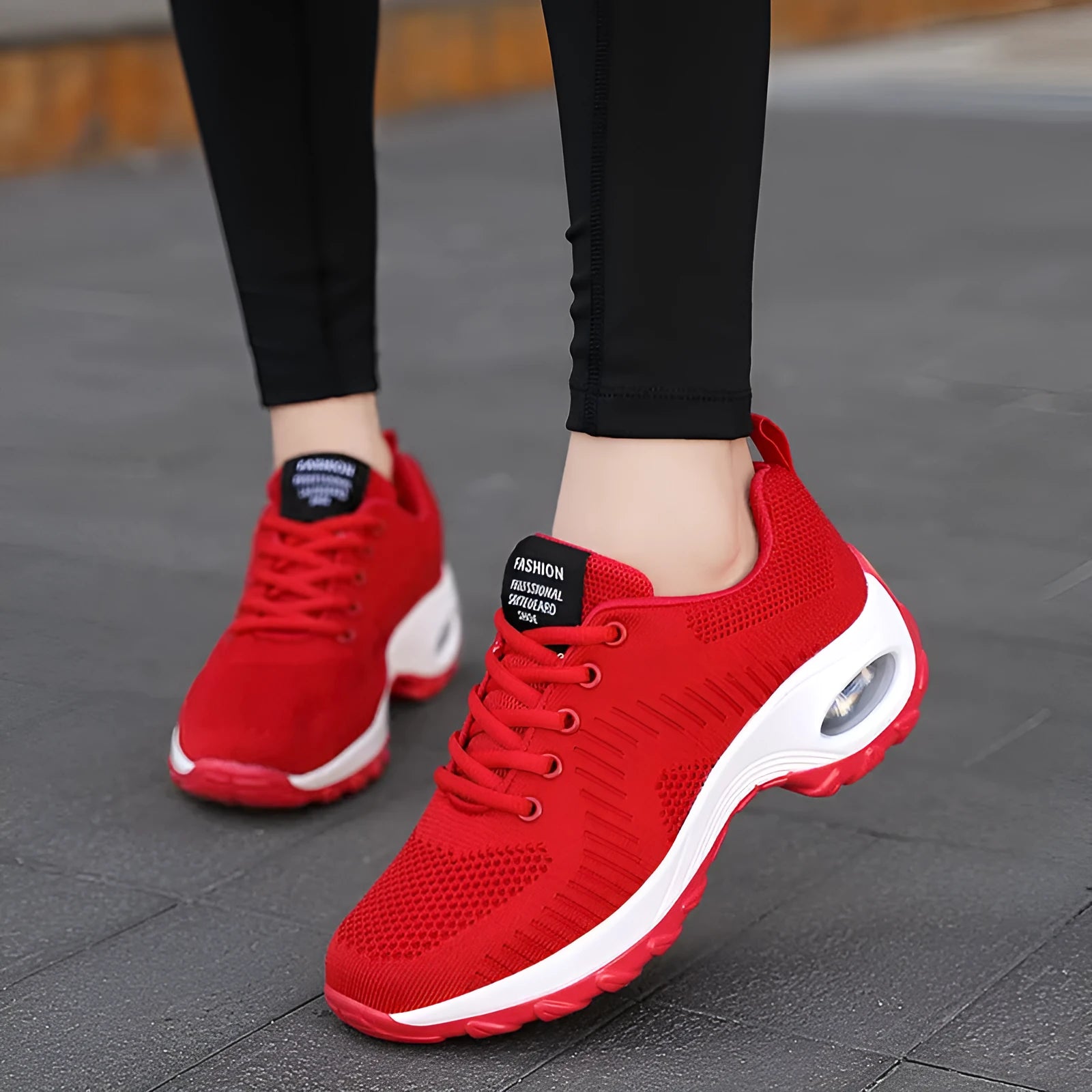 Red and black women's low-top mesh sneakers with round toe, front laces, and a mid heel on a white background.