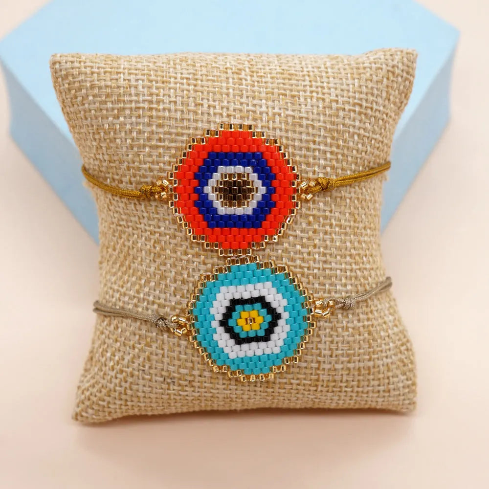 Hand-woven glass bead bracelet with blue eyes devil eyes motif on white background