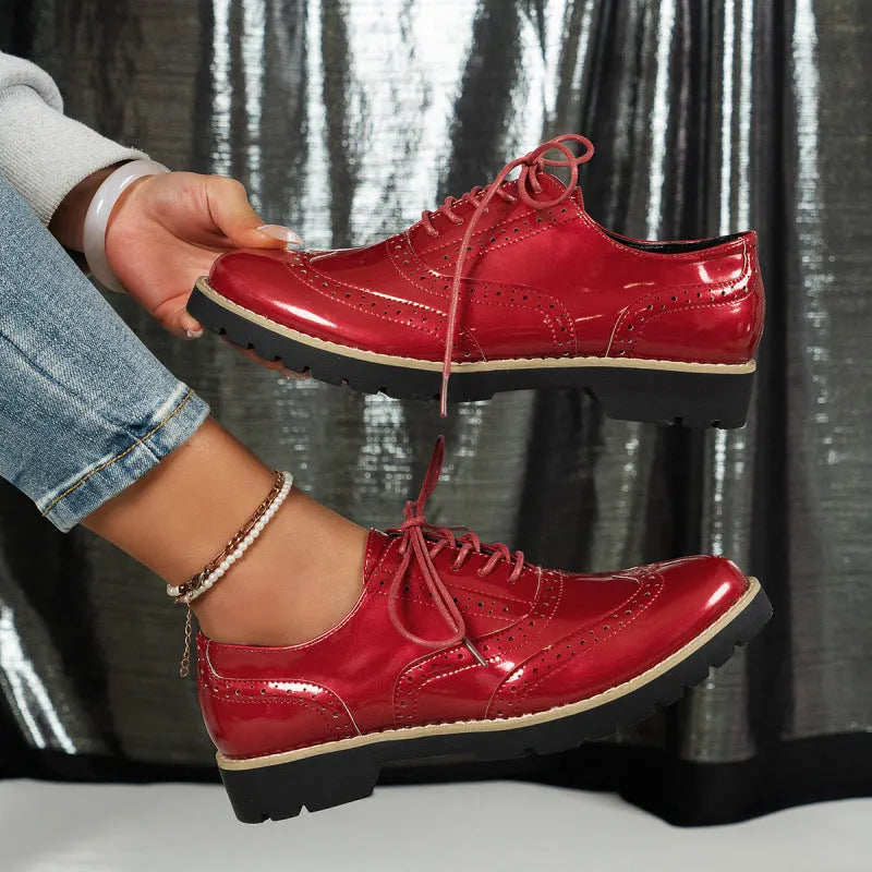 Women's black PU leather lace-up loafers with sequin details and a wedge heel, shown on a foot.