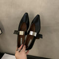 Women's black pointed toe Mary Jane buckle shoes with a low flat rubber sole.