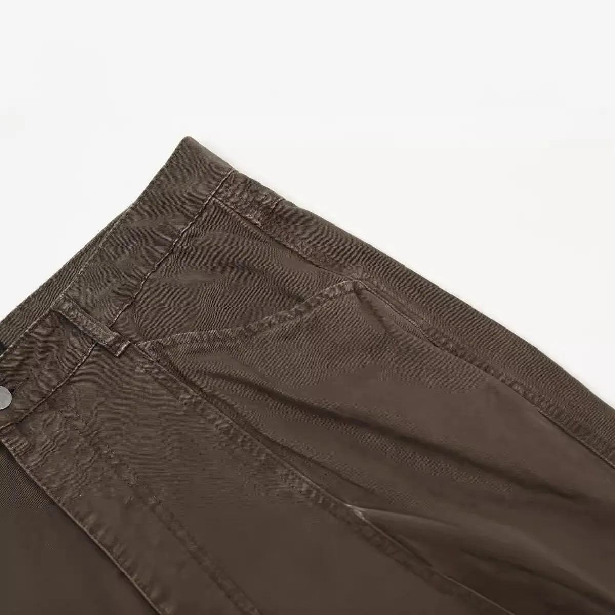 Men's brown loose-fit high-waisted straight-leg cotton trousers on a hanger.