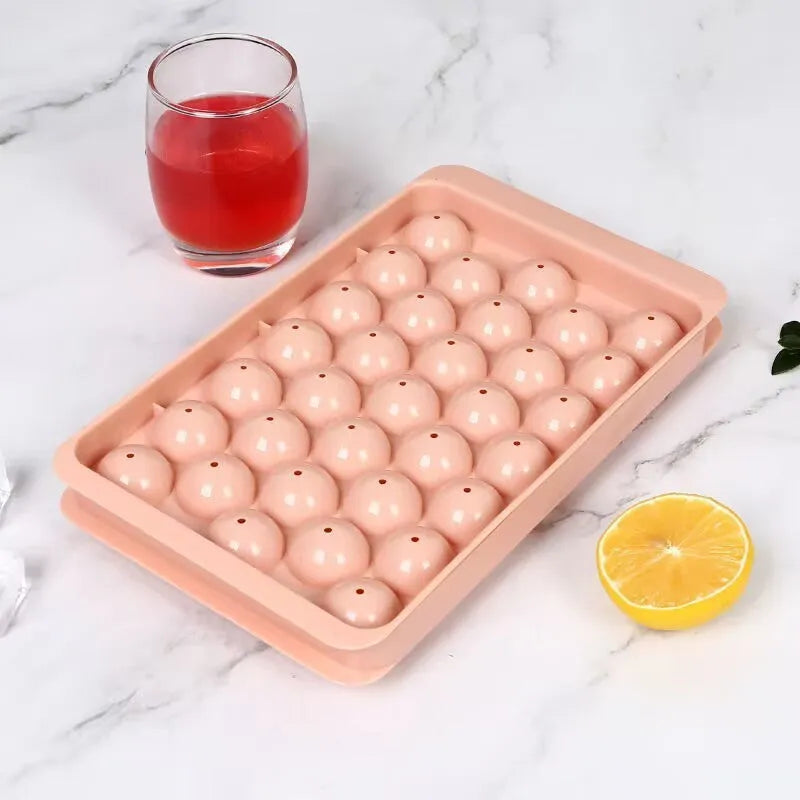 Blue 33-grid round silicone ice cube tray with transparent lid next to pink version, showing dimensions.