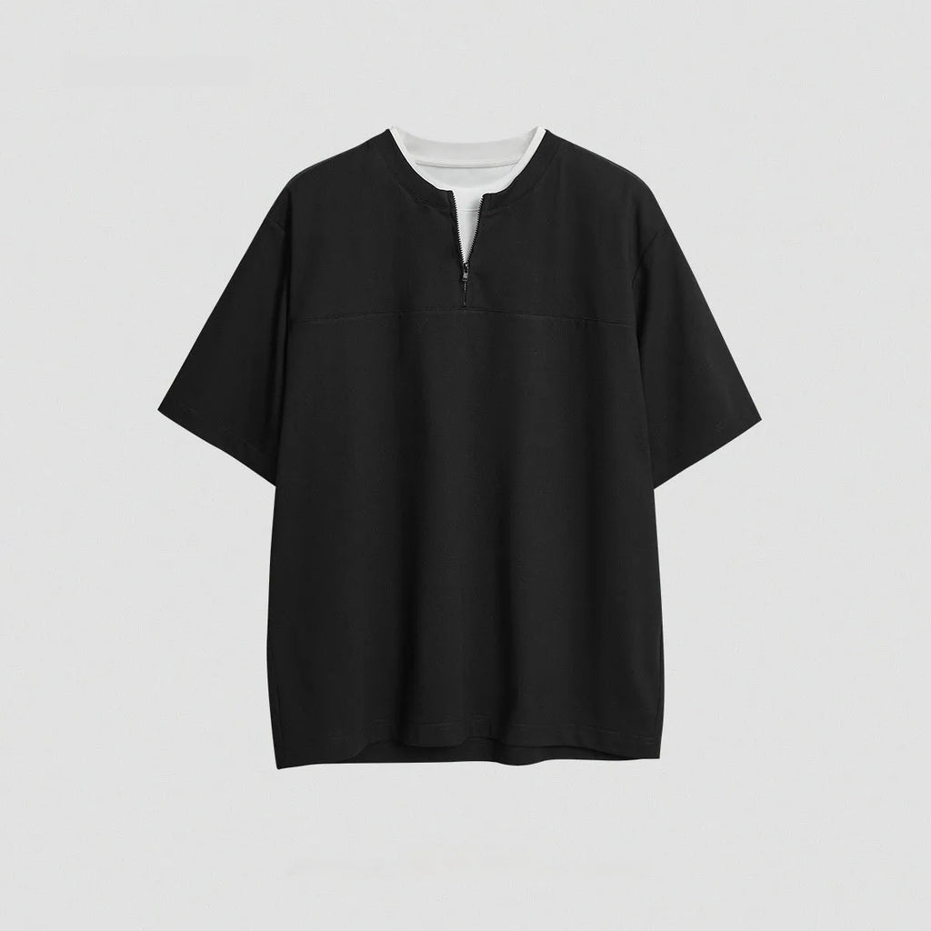 Loose blue zip-through patchwork top on a hanger, showing the false two-piece design and collar detail.