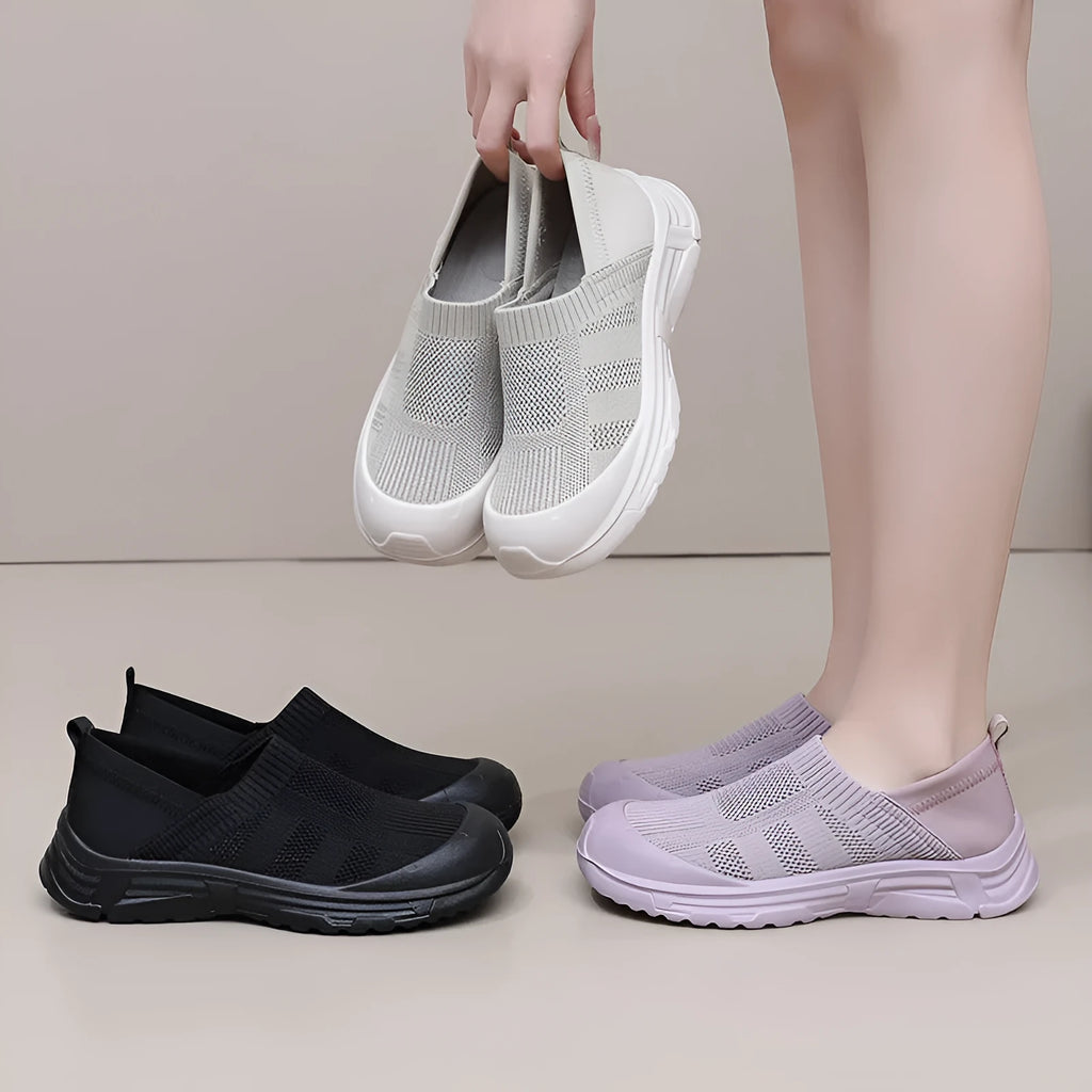Women's black slip-on shoe with a cloth upper and soft PVC sole on a white background