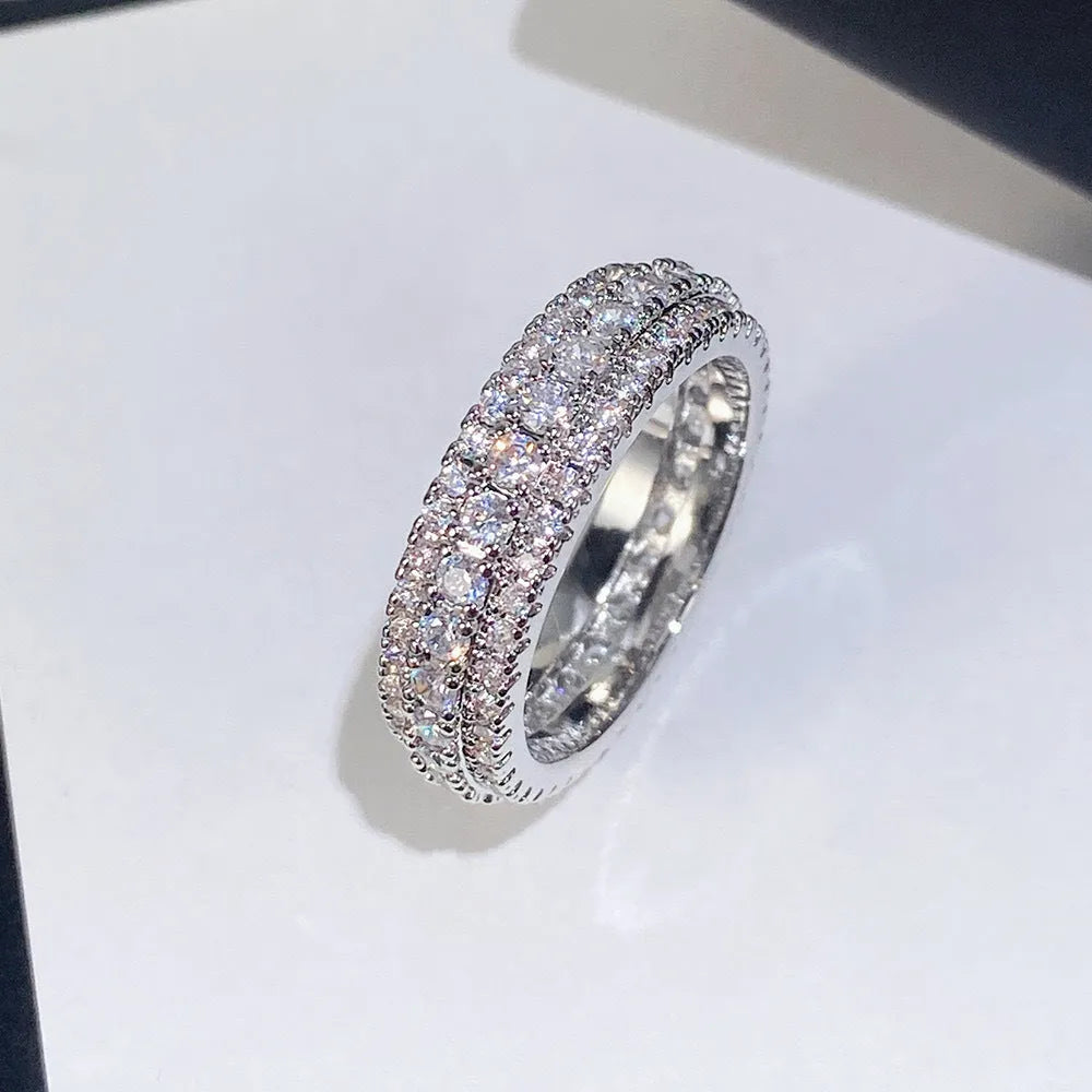 Geometric triangle zircon engagement ring in copper on a finger, showing white gold colour finish.