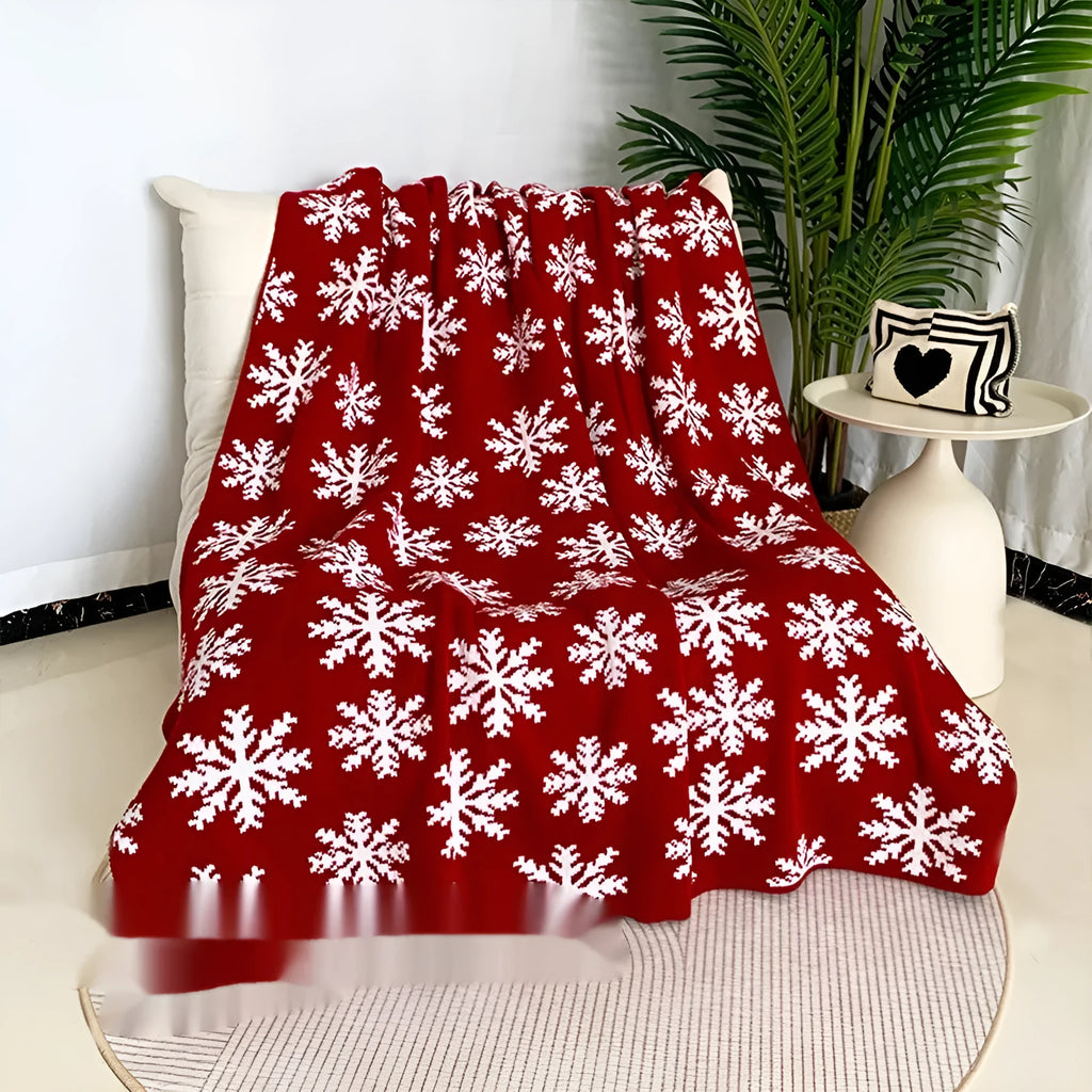 Personalised acrylic Christmas blanket with reindeer pattern draped over a grey sofa