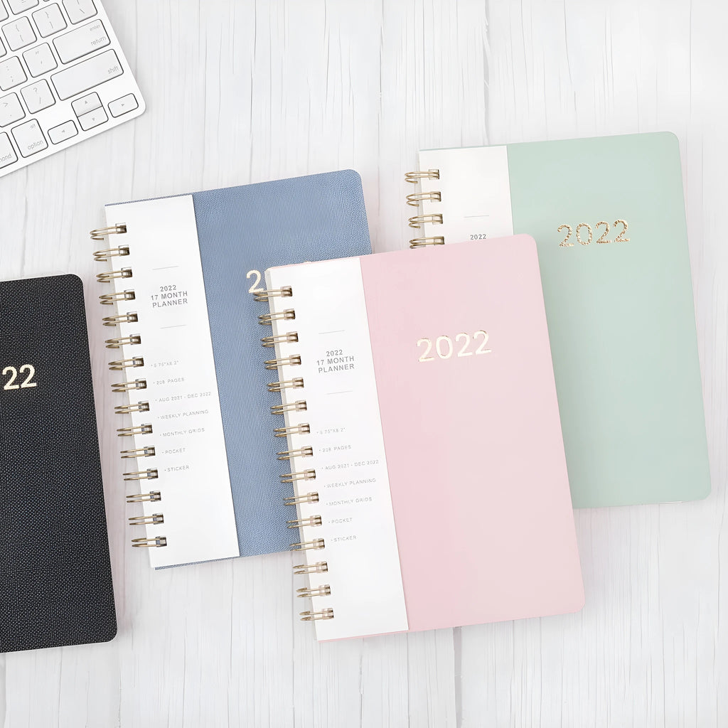 Blue or green PU leather student plan notebook with coil binding showing 2022 week planner pages and interior pockets