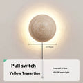 Vintage semicircle wall lamp with a yellow cave stone shade and iron base, showing the pull switch.