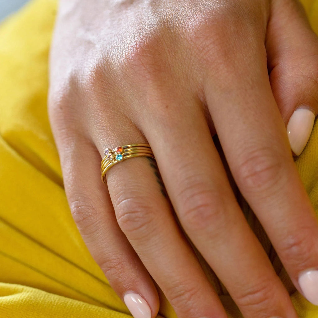 Gold tone titanium steel ring with a December birthstone in an engraved geometric design.