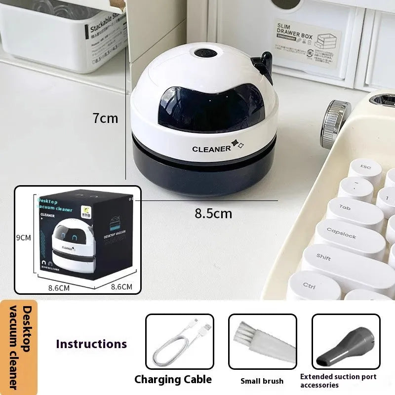USB-powered handheld desktop vacuum cleaner in blue rocket design on a wooden desk next to a keyboard.