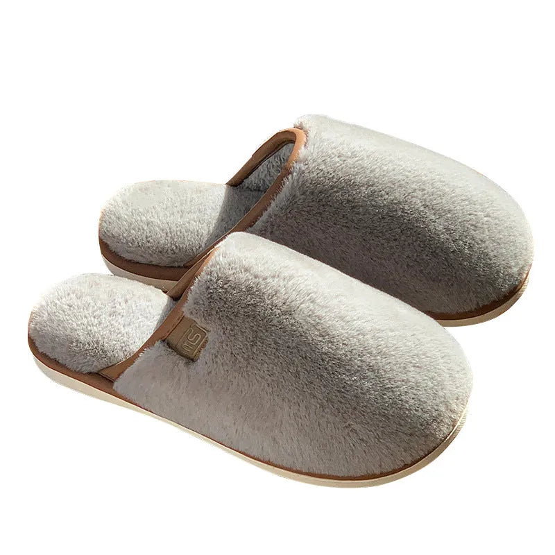 Pair of solid-colour plush winter slippers with a PVC upper and textured non-slip sole.