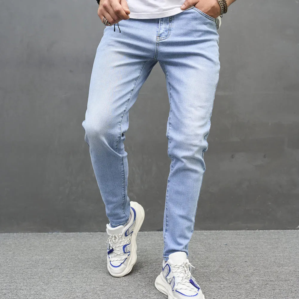Light blue skinny cotton stretch men's jeans with mid waist and tapered leg on model