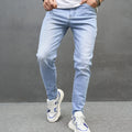 Light blue skinny cotton stretch men's jeans with mid waist and tapered leg on model