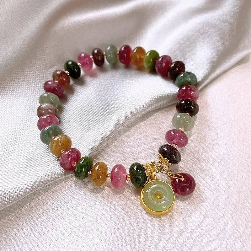 Close-up of a colourful tourmaline rabbit pendant bracelet with natural stone round beads.