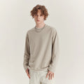 Man wearing a loose-fit long-sleeved cotton blend t-shirt in a solid colour, showing the round neck and casual style.