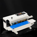 Compact white and grey handheld heat sealer with a date printing wheel, shown sealing a plastic bag.