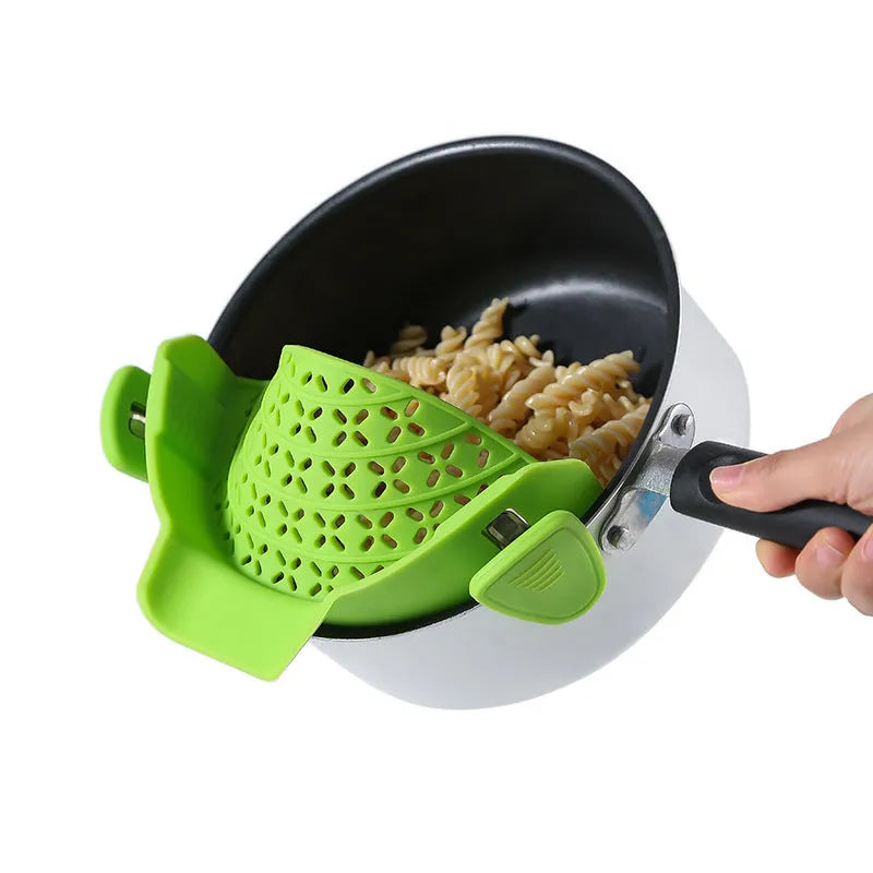 Green silicone pot rim drainer with stainless steel frame on a kitchen counter.