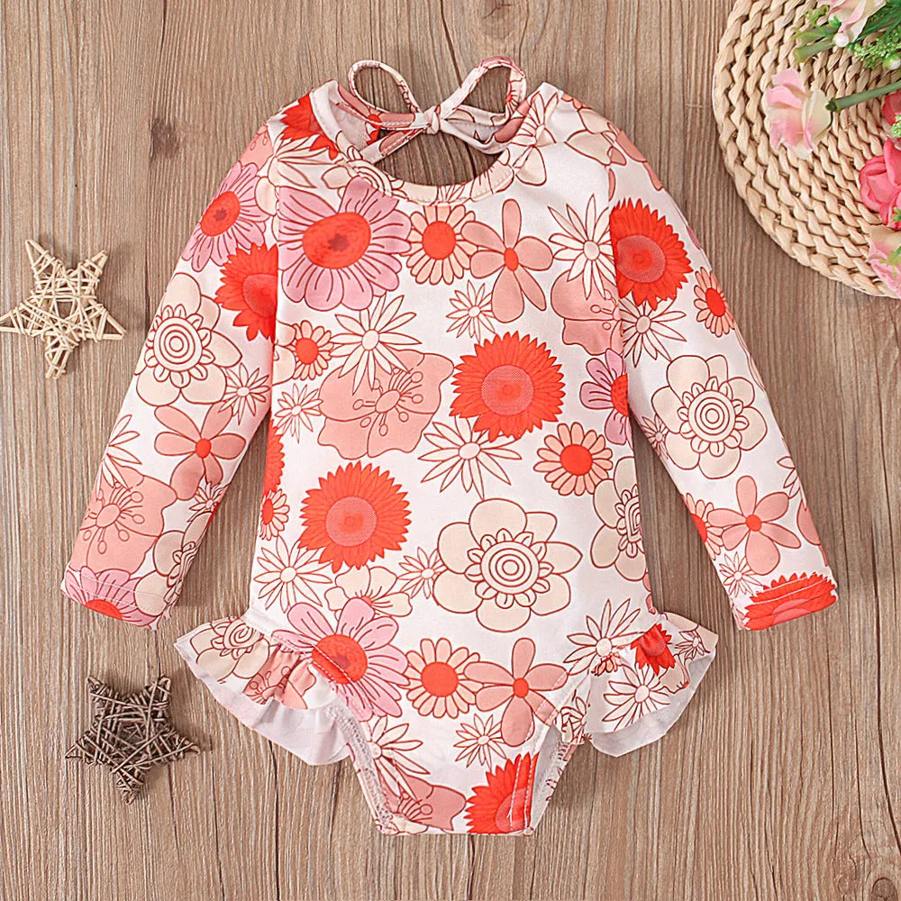 Girl's floral print open back swimsuit in orange, showing crew neck and briefs style.
