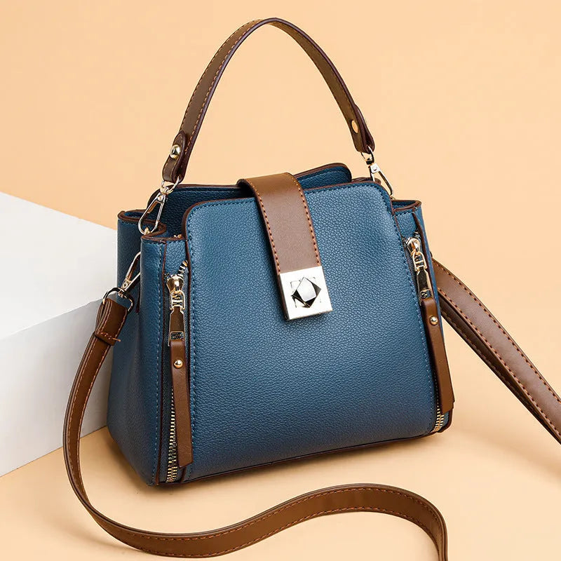 Women's large-capacity PU crossbody bucket bag with three-dimensional outer pocket and splicing detail, shown in black, red, or blue