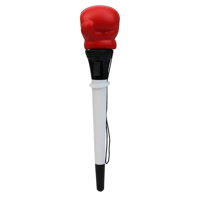 Set of four black pressure relief pens with a boxing press ejection mechanism on a desk.