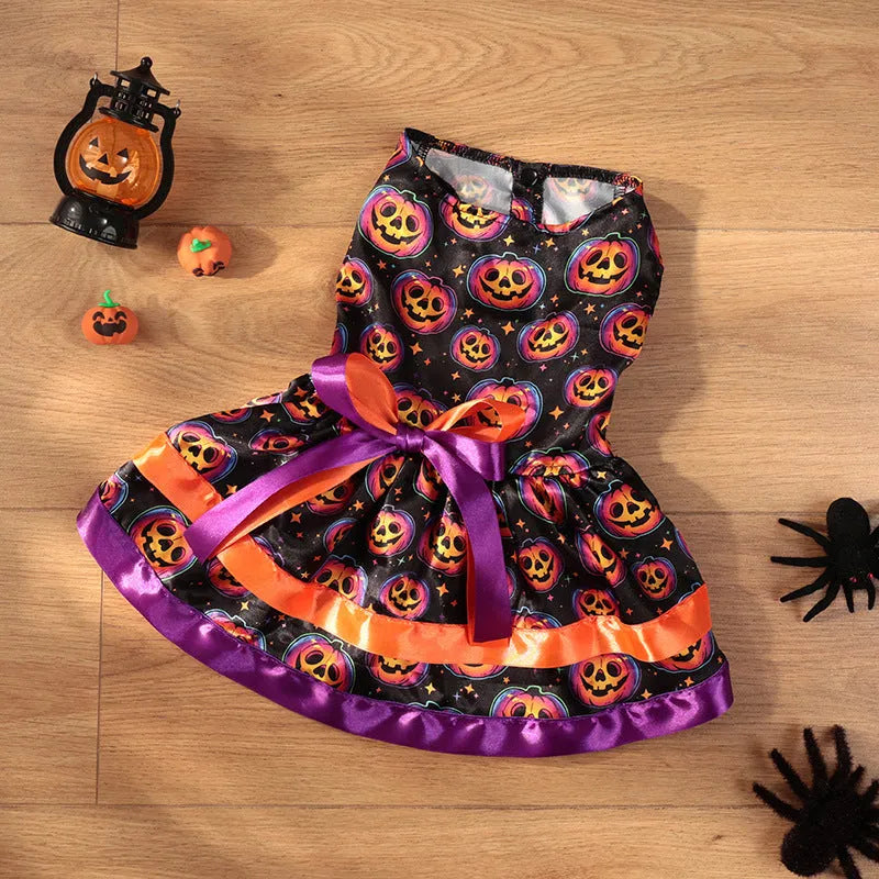 A dog wearing a double-layer orange Halloween skirt with a colourful pumpkin print.
