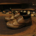 Light brown men's vintage casual leather shoes with hand-carved distressed detailing and a round toe.