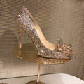 Gold women's stiletto high heels with rhinestone decoration and a pointed toe.
