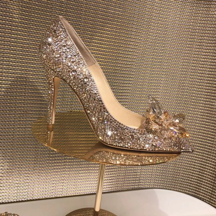 Gold women's stiletto high heels with rhinestone decoration and a pointed toe.