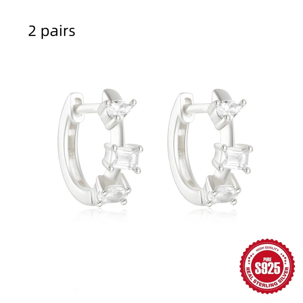 A pair of small round geometric stud earrings in sterling silver with an electroplated finish.