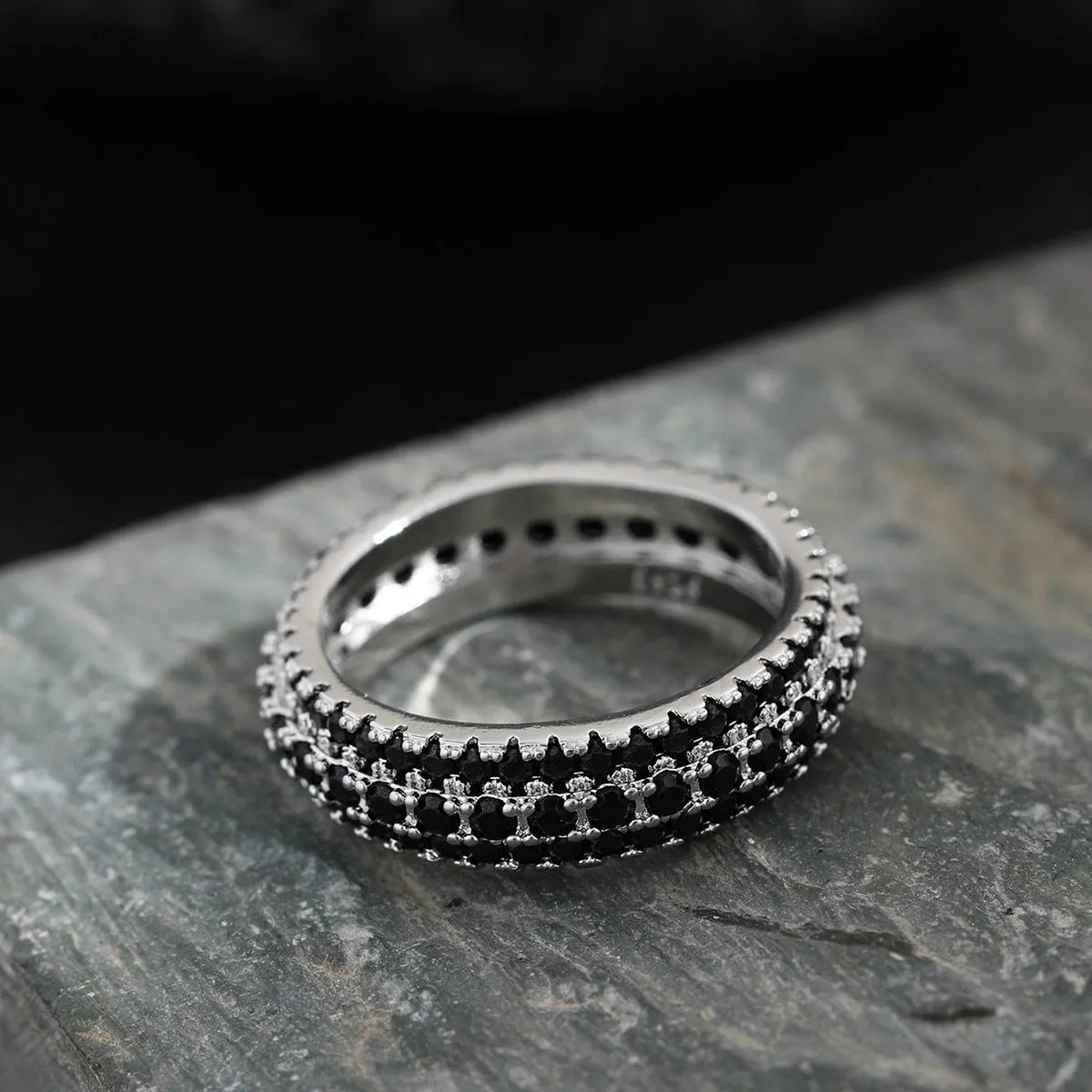 Geometric triangle zircon engagement ring in copper on a finger, showing white gold colour finish.