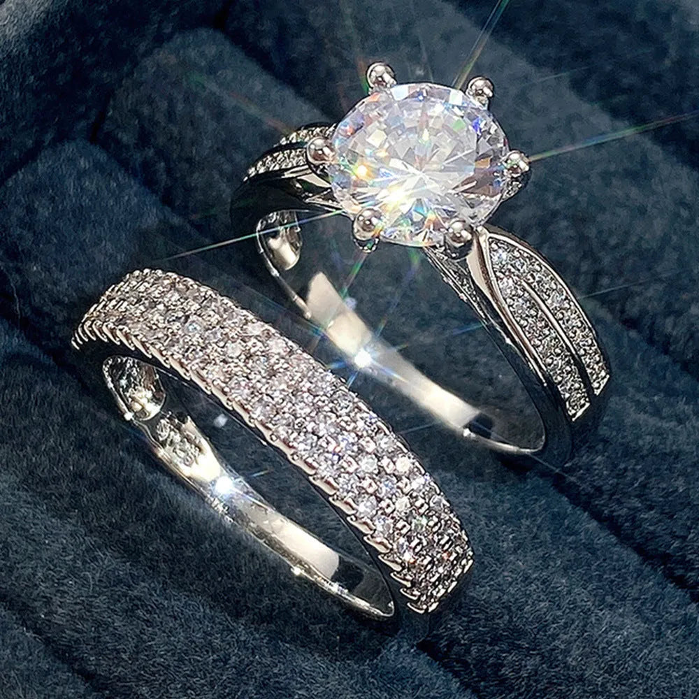 A geometric white gold-coloured alloy wedding ring bracelet on a finger, showing its continuous band design with a round detail.
