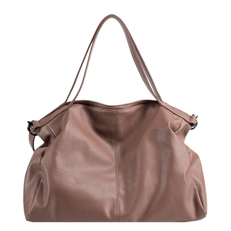 Large soft surface casual messenger bag in black showing horizontal shape and shoulder strap.