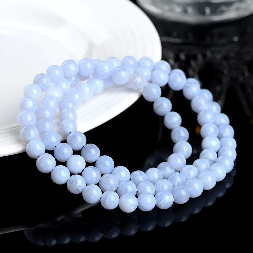 Close-up of a blue striped agate beaded bracelet with Ruyi design on a neutral background.