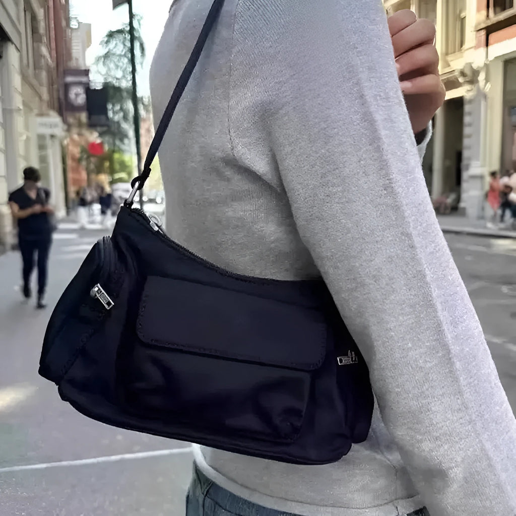Simple black lightweight nylon shoulder bag with double pockets showing side line detailing