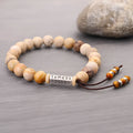 Handmade wood colour stone bead bracelet with adjustable closure on wooden background
