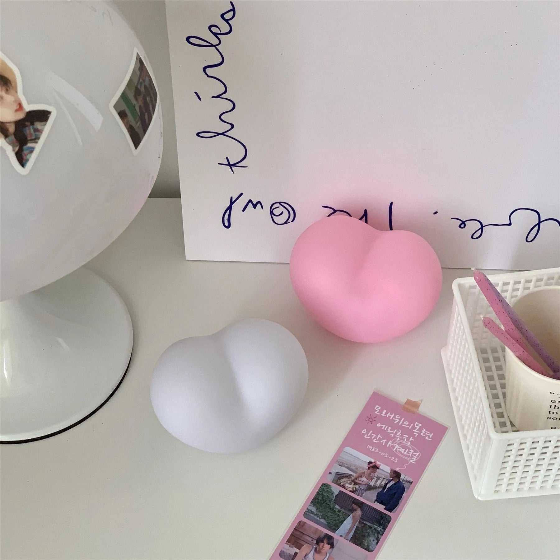 White and pink vinyl atmosphere lamps in small and large sizes with warm glowing light.