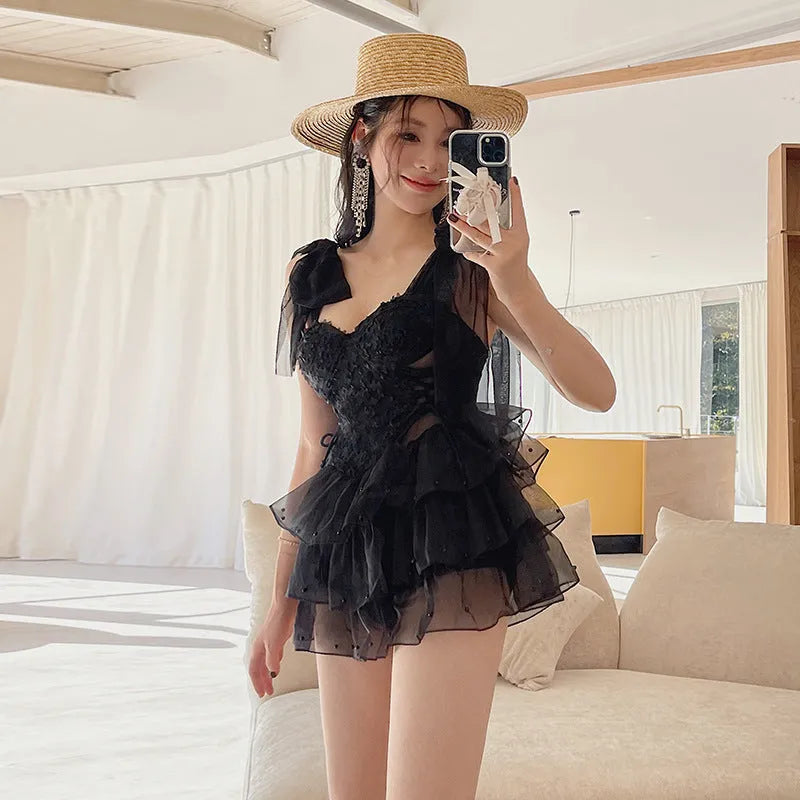 Black solid colour women's one-piece swimsuit with a gathered chest detail.