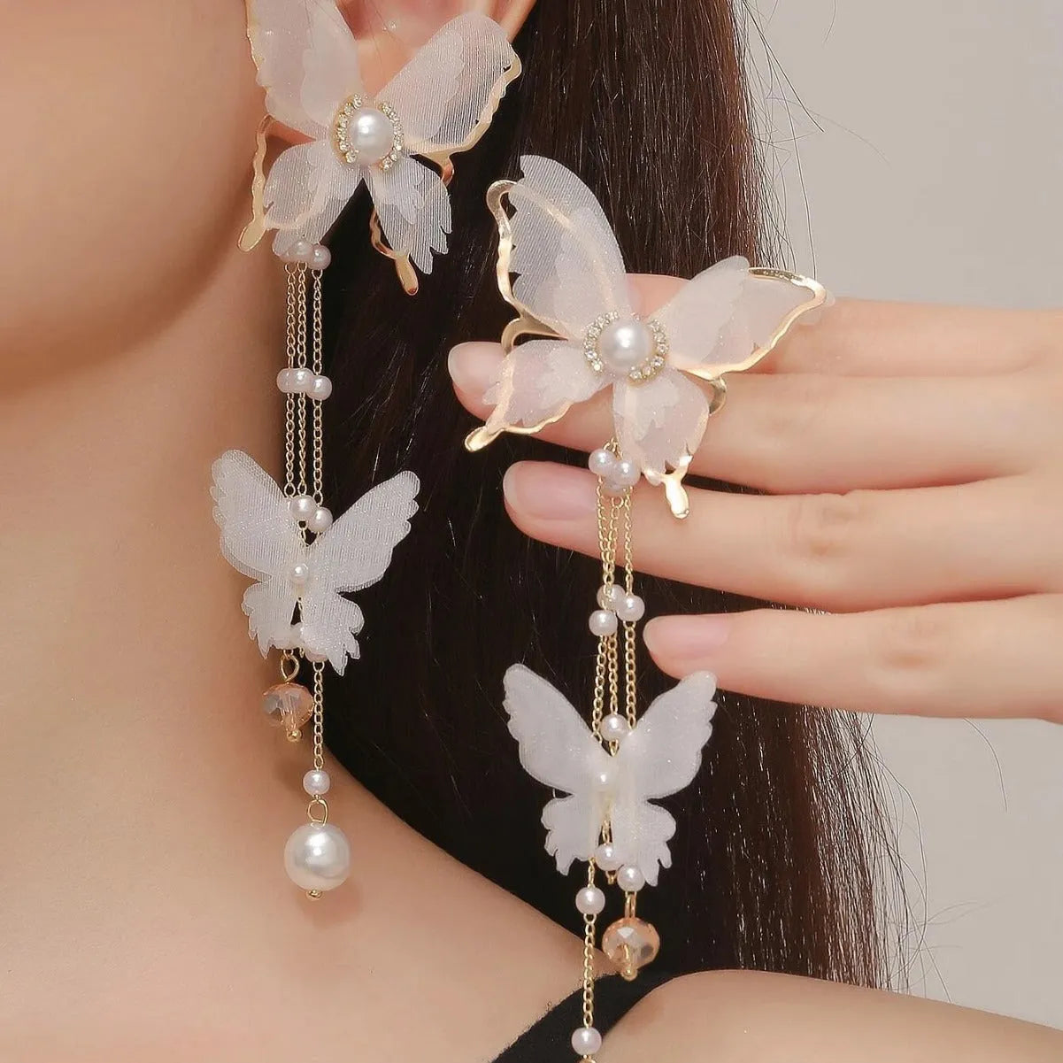 White butterfly-shaped earrings with lace detail, pearl tassels, and rhinestones on a copper alloy base.